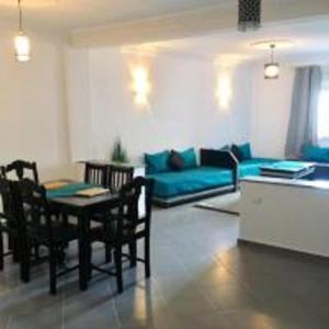 een woonkamer met een tafel en een blauwe bank bij Appart Hôtel Tanger Paname in Tanger