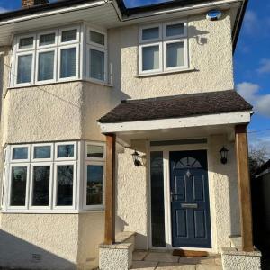 a white house with a blue door and windows at Oxford Kidlington 6 Bed 5 mins to Oxford Parkway in Kidlington