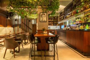 a restaurant with tables and chairs and a bar at Hotel Square by MARGO in Pristina