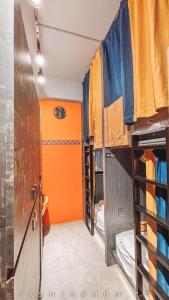 ein Zimmer mit vielen Etagenbetten in Orange und Blau in der Unterkunft 澎湖 玩聚背包民宿 in Huxi