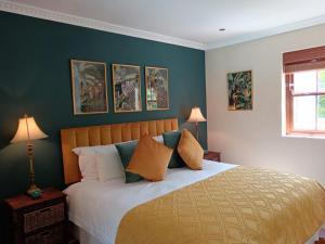 - une chambre avec un grand lit aux murs verts dans l'établissement d'Vine Maison, à Franschhoek