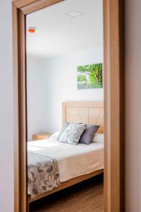 um reflexo de espelho de uma cama num quarto em Hotel Gastronómico Gandainas em Riós
