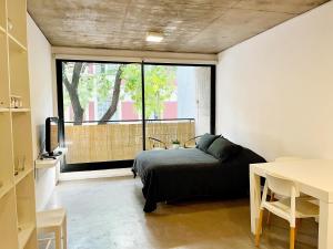 a bedroom with a bed and a large window at Mono Ambiente en Palermo Hollywood in Buenos Aires +24 photos