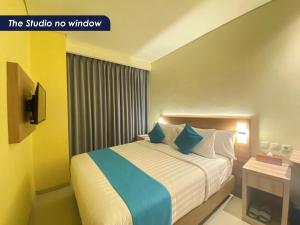 ein Hotelzimmer mit einem Bett mit blauen Kissen in der Unterkunft Zasgo Hotel in Labuan Bajo
