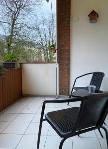 une chaise noire et une table sur une terrasse dans l'établissement Monteurwohnung Neuss, à Neuss