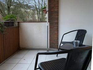 un patio con mesa y sillas en un porche en Monteurwohnung Neuss, en Neuss
