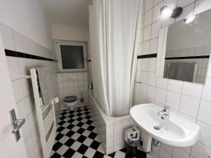 La salle de bains blanche est pourvue d'un lavabo et de toilettes. dans l'établissement Monteurwohnung Neuss, à Neuss