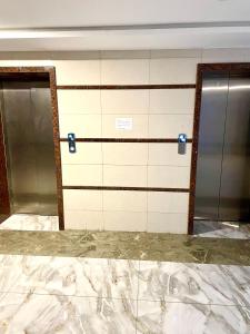 a bathroom with two elevators and a marble floor at Entire Studio Apartment in Islamabad
