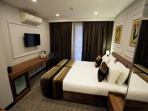 um quarto de hotel com uma cama e uma televisão em Zalel Hotels Laleli em Istambul