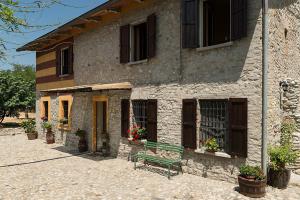 a green bench sitting outside of a building at B&B Mulino Marsa in CastellʼArquato