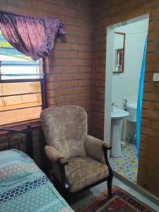 a bedroom with a chair and a sink and a bed at SJ Kololi Apartments in Sere Kunda