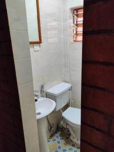 a small bathroom with a toilet and a sink at SJ Kololi Apartments in Sere Kunda