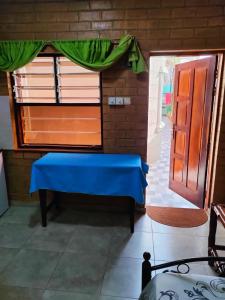 a room with a blue bench and a door at SJ Kololi Apartments in Sere Kunda