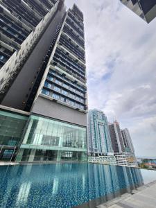 a tall building with a swimming pool in front of it at Setia Sky88 Johor Bahru in Johor Bahru