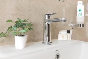 a sink with a faucet and a plant on it at Hotel Dralha in Thimphu +24 photos