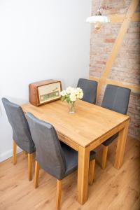 una mesa de madera con sillas y un jarrón con flores en Historisches Ambiente im Fürstenbahnhof Lübstorf en Lübstorf