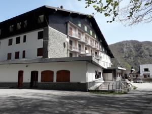 a large white building with a black roof at Monolocale Abetone Cutigliano in Pian di Novello