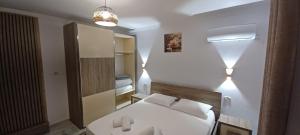 1 dormitorio con cama blanca y lavamanos en Hyka The Stone House en Shkodër