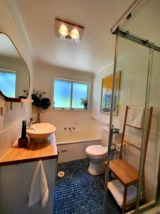 a bathroom with a sink and a toilet and a shower at The Yellow Koala - Vibrant Home in Medlow Bath in Medlow Bath