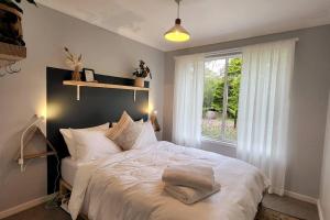 a bedroom with a white bed and a window at The Yellow Koala - Vibrant Home in Medlow Bath in Medlow Bath