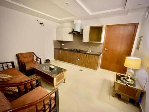 a living room with a table and a kitchen at Entire Studio Apartment in Islamabad