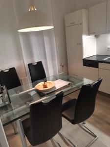 a glass table with black chairs and a plate on it at Im Harzer Vogelnest Spatzennest in Bad Harzburg +6 photos