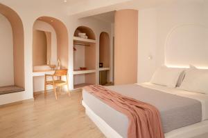 a bedroom with a bed and a desk with a chair at Aloni Hotel & Suites in Piso Livadi
