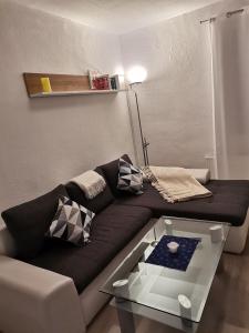 a living room with a black couch and a glass table at Im Harzer Vogelnest Spatzennest in Bad Harzburg