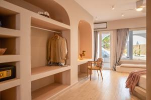 a bedroom with a dressing room with shelves at Aloni Hotel & Suites in Piso Livadi