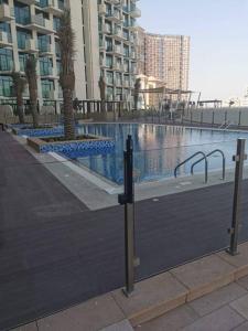 a large swimming pool with palm trees and buildings at Burj Khalifa & City Skyline View, Full Furnish Studio in Dubai