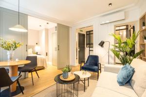 a living room with a couch and a table and chairs at Edmond Vibes Puerta del Sol Suites in Madrid +61 photos