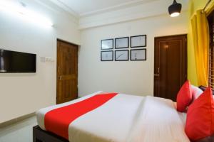 a bedroom with a large bed with red pillows at Goroomgo Mks Inn Bhubaneswar in Bhubaneshwar