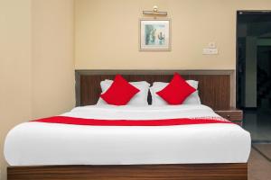 a bedroom with a bed with red pillows at OYO Hill Grand Himalaya in Darjeeling