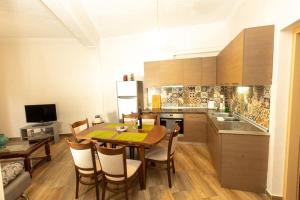 una cucina con tavolo e sedie in una stanza di Spacious Apartment in Old Town - private parking a Salonicco