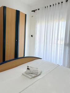 クサミルにあるKel Roomsの鏡の前のベッドに座るタオル