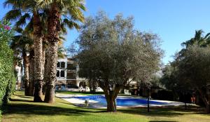 una piscina con árboles y un edificio de fondo en Atico GOLFSTAR, en Villacosta