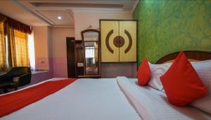 una camera da letto con un grande letto con cuscini rossi di Pax in hotel a Udaipur