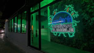a neon sign in the window of a building at Urban Jungle Hostel in Bangkok