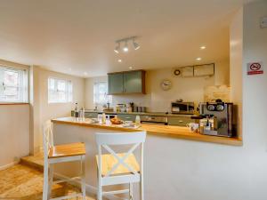a kitchen with a counter with two chairs and a stove at 1 bed in Ledbury 90349 in Eldersfield