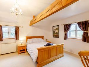 a bedroom with a wooden bed and windows at 1 bed in Ledbury 90349 in Eldersfield