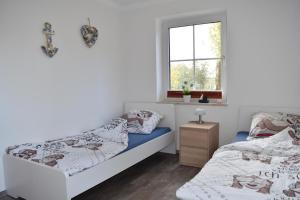 a bedroom with two beds and a window at Ferienwohnung - Unsere Wenke in Lemkendorf