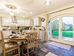 a kitchen and dining room with a table and chairs at 3 Bed in Ellingham 90380 in Eglingham