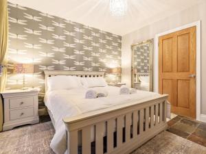 a bedroom with a large white bed and a mirror at 3 Bed in Ellingham 90380 in Eglingham