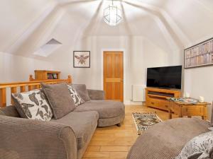 a living room with a couch and a flat screen tv at 3 Bed in Ellingham 90380 in Eglingham