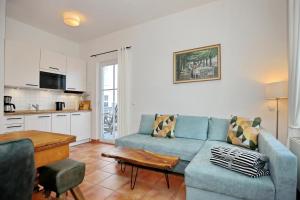 uma sala de estar com um sofá azul e uma cozinha em Strandstraße 16 Wohnung 09 em Kühlungsborn