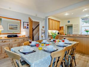 a dining room with a table with chairs and a kitchen at 5 Bed in Aberdovey 90493 in Aberdyfi
