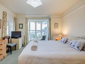 a bedroom with a large white bed and a window at 5 Bed in Aberdovey 90493 in Aberdyfi