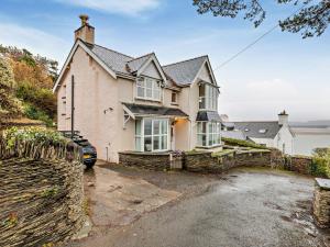 a house with a stone wall and a driveway at 5 Bed in Aberdovey 90493 in Aberdyfi