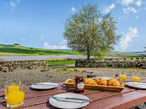 una mesa con una bandeja de pan y vasos de zumo de naranja en 2 Bed in Barnard Castle 90498, en Middleton in Teesdale