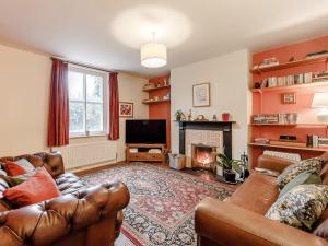 a living room with leather furniture and a fireplace at 4 Bed in Wylam 90433 in Wylam